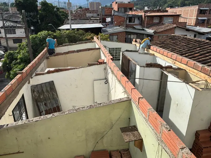 Cuadrilla iniciando la reconstrucción de la cubierta de una casa en Medellín